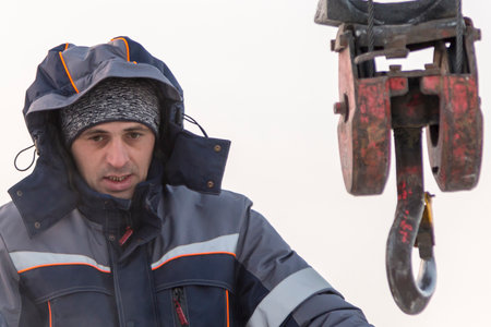 A portrait of a fitter in a blue jacket at the hook