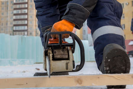 Portrait of a worker in a blue jacket with a hood at the hook of a truck crane at the construction...