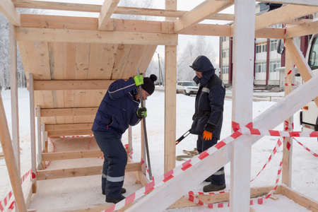 Worker on timber frame construction with crowbar in handの写真素材