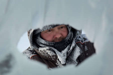 The sculptor cuts an ice figure out of a block of ice for Christmas