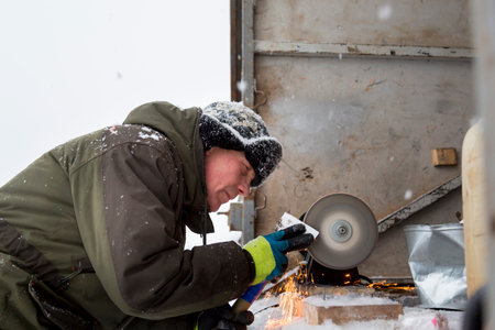 The sculptor sharpens the working tool on the emery wheelの写真素材