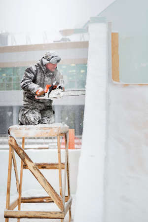 Worker with a chainsaw in hand at the assembly siteの写真素材
