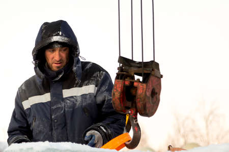 Close-up of the face of a worker in a blue jacket at the workplace