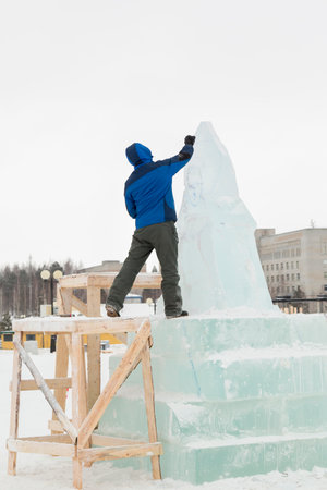 Portrait of a working assembler in a blue knitted hat jacket at the workplaceの写真素材