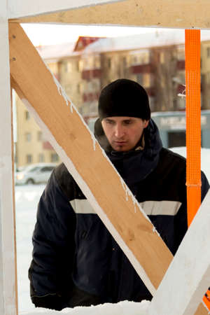 The builder cleans the ice panel with a wire brush from snow
