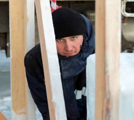 Portrait of a male assembler at the workplace in winter overallsの写真素材