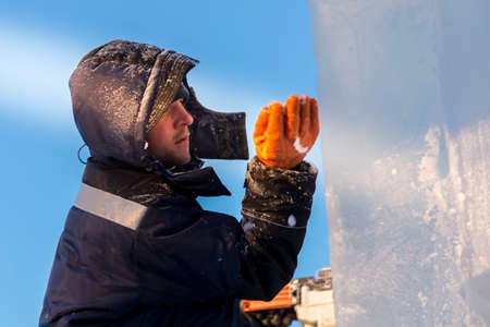 Portrait of a male assembler at the workplace in winter overallsの写真素材