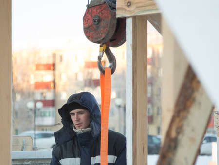 Portrait of a male assembler at the workplace in winter overallsの写真素材