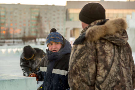 Two assembly workers unload ice plates from the body of a carの写真素材
