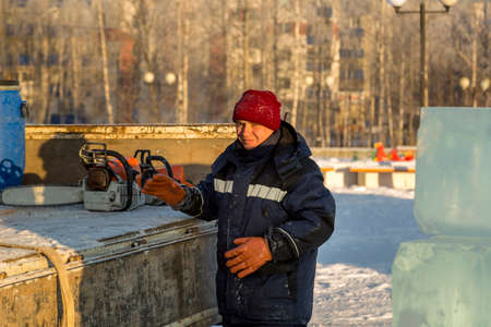Portrait of a worker in a blue jacket with a hood at the hook of a truck craneの写真素材
