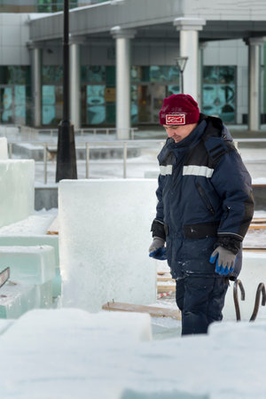 Portrait of a worker in a blue jacket with a hood at the hook of a truck craneの写真素材