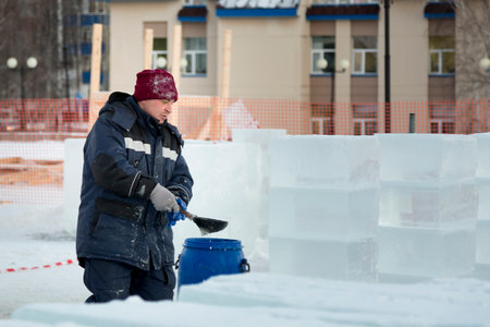 Portrait of a worker in a blue jacket with a hood at the hook of a truck craneの写真素材