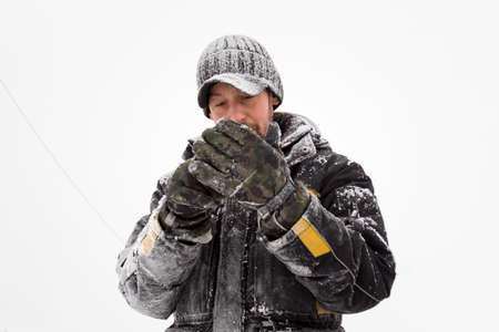Fitter in a jacket and a black cap with a visor puts on gloves