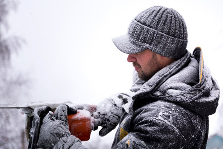 Fitter in a jacket and a black cap with a visor puts on gloves