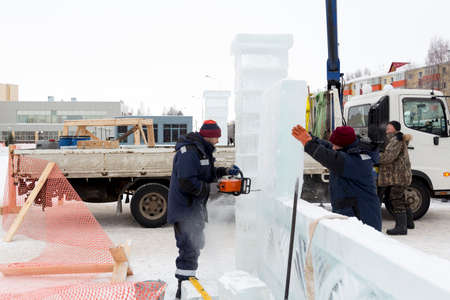 Three assembly workers stacking ice slabs on a construction site