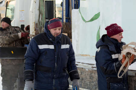 A worker pushes the ice blocks apart with a crowbar