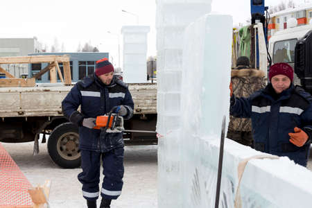 A worker pushes the ice blocks apart with a crowbarの写真素材