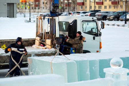 Slingers unload ice slabs with a truck craneの写真素材