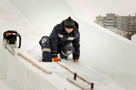 Worker with a chainsaw in hand at the assembly site