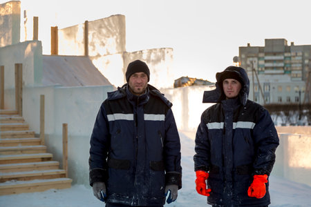Portrait of two installers at the construction site of the ice town
