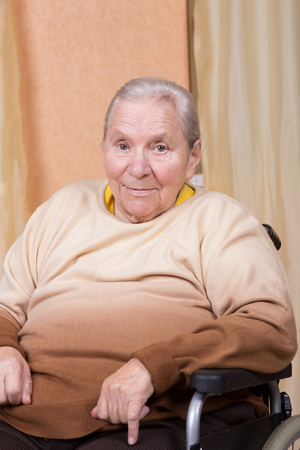 Eighty years old woman sitting in a wheelchairの写真素材