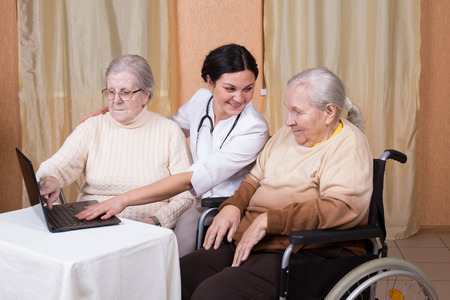 couple of senior Woman with carer Learning Computer Togetherの写真素材