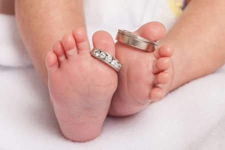 Baby feet with wedding rings parents.