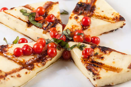 Tasty starter before the main course; grilled cheese with cherry tomatoes.の写真素材