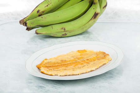 Patacon or toston fried and flattened pieces of green plantain, traditional snack or accompaniment in the Caribbean.の写真素材