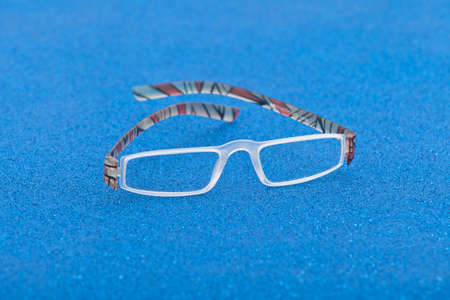 Fashion and style; eyeglasses on a blue background.