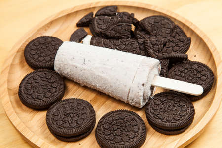 Ice cream - tasty and refreshing ice cream flavored cookies and cream, photo on wooden background.の写真素材