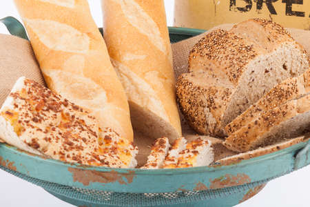 Bowl with different and tasty breads; photo on white background.