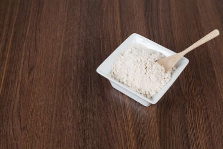 Healthy oatmeal powder; photo on wooden background.