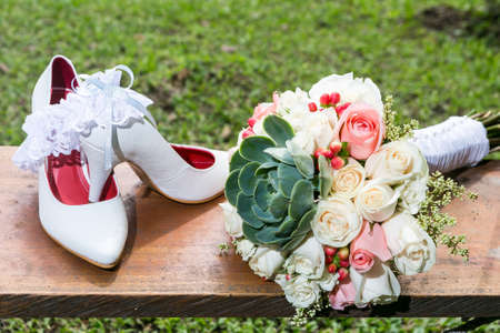 Bouquet of flowers and shoes for the bride on wedding day.の写真素材