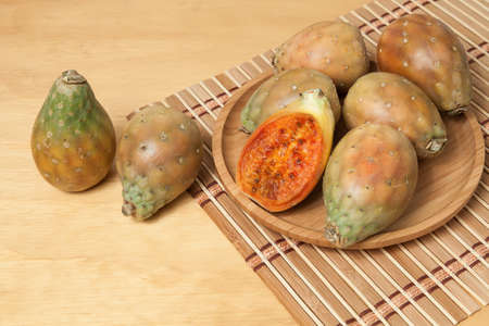 Prickly pear cactus fruits - Opuntia ficus indica; photo on wooden background.
