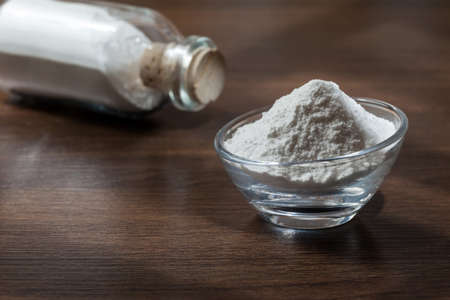Baking soda (sodium bicarbonate) on dark wooden background.の写真素材