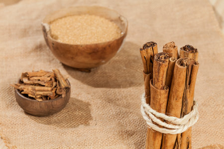 cinnamon stick and brown sugar; photo on wooden background.