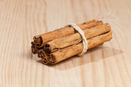 Several rolls of Canela en Rama tied with a rope; photo on wooden background.の写真素材
