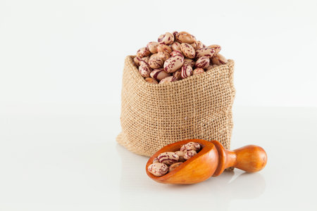 Pinto beans, a legume native to the American continent; photo on white background.