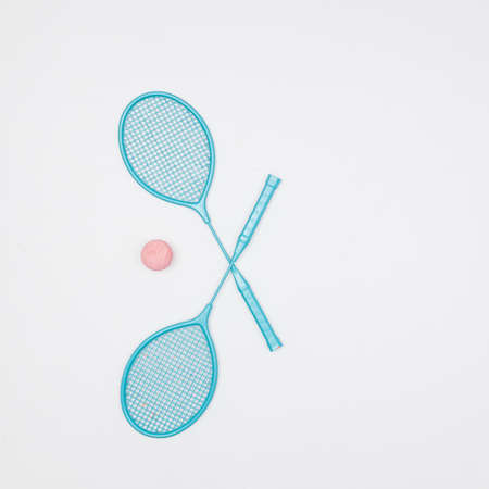 Colorful tennis rackets and ball on white background.