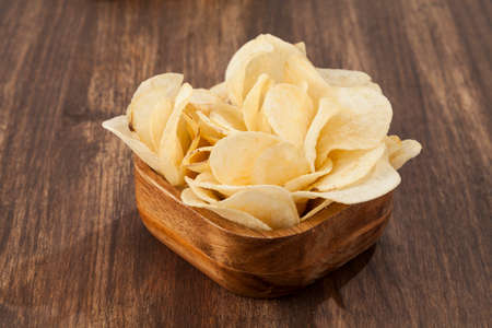 Wooden Bowl With Tasty Potato Chips; Photo On Wooden Background
