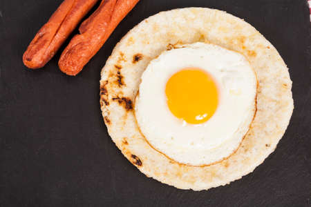 Traditional Latin American Breakfast; White Corn Arepa with Fried Egg And Sausagesの写真素材