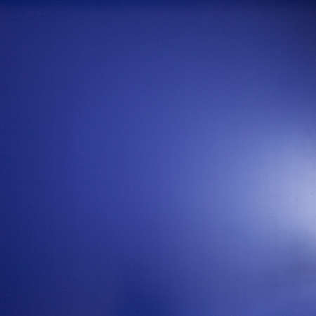 Background and texture - flat blue background with light flare.