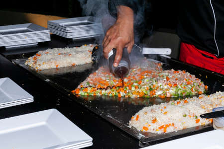 Chef Hands Cooking Food On Griddle; Rice with Vegetables