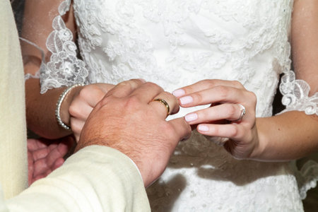 Hands Of The Bride And Groom Placing Wedding Rings.の写真素材