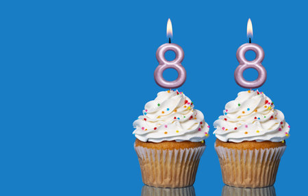 Birthday Cupcakes With Candles Lit Forming The Number 88 - Photo On Blue Background