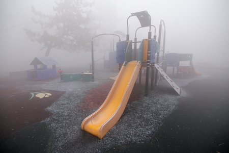 Playground in heavy fog at dawn in a parkの写真素材