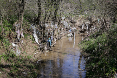 Heavy polluted water stream with domestic garbage