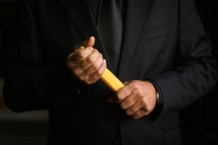 Details of mourning man holding candles at a funeral in a orthodox christian churchの写真素材