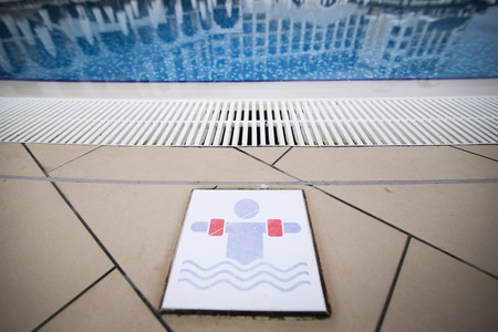 Sign near the pool as a warning that children must wear life saving inflatable rings when swimmingの写真素材